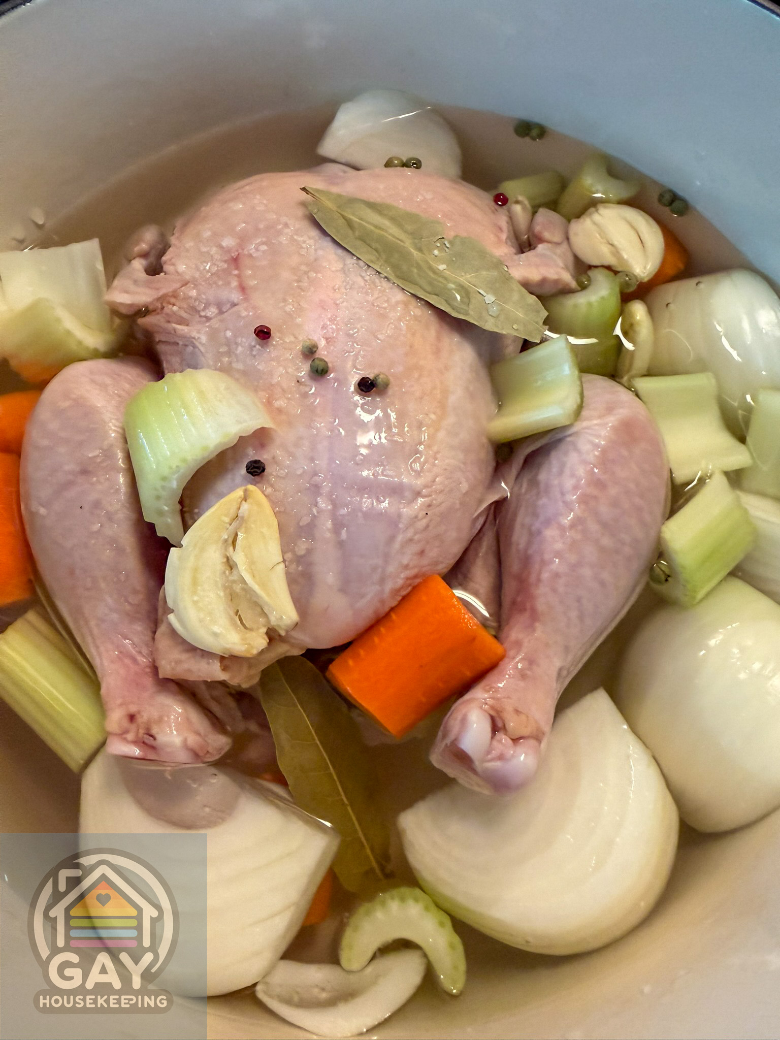 The chicken and aromatics covered with water in the Dutch oven, ready to simmer.