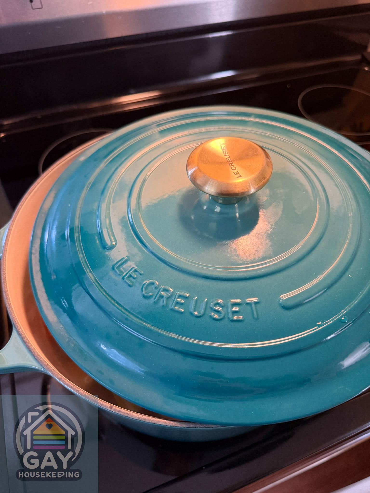 The teal Le Creuset with its lid on, keeping the simmer gentle.