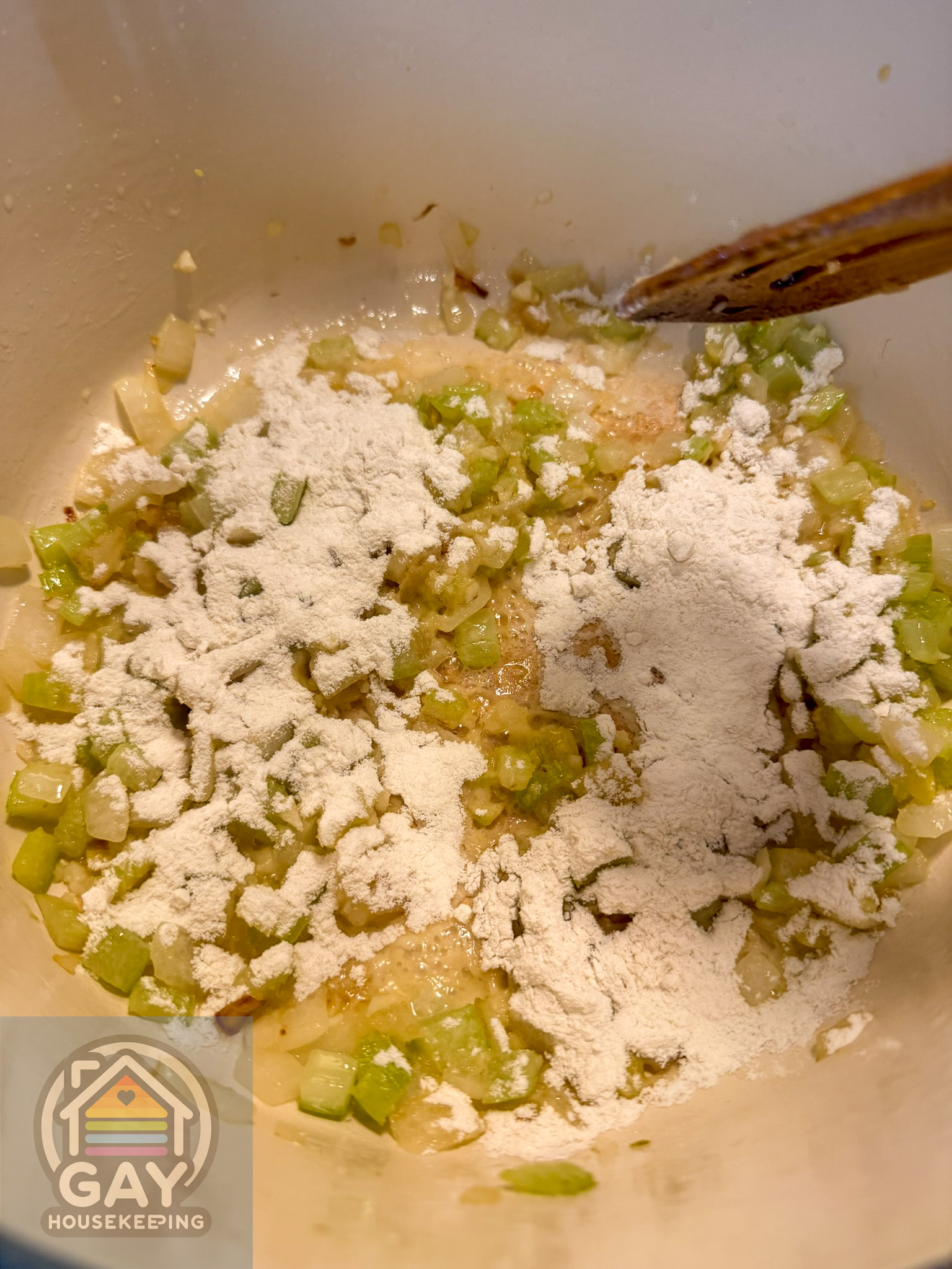 Flour sprinkled over the sautéed vegetables, ready to be stirred into a thick paste.