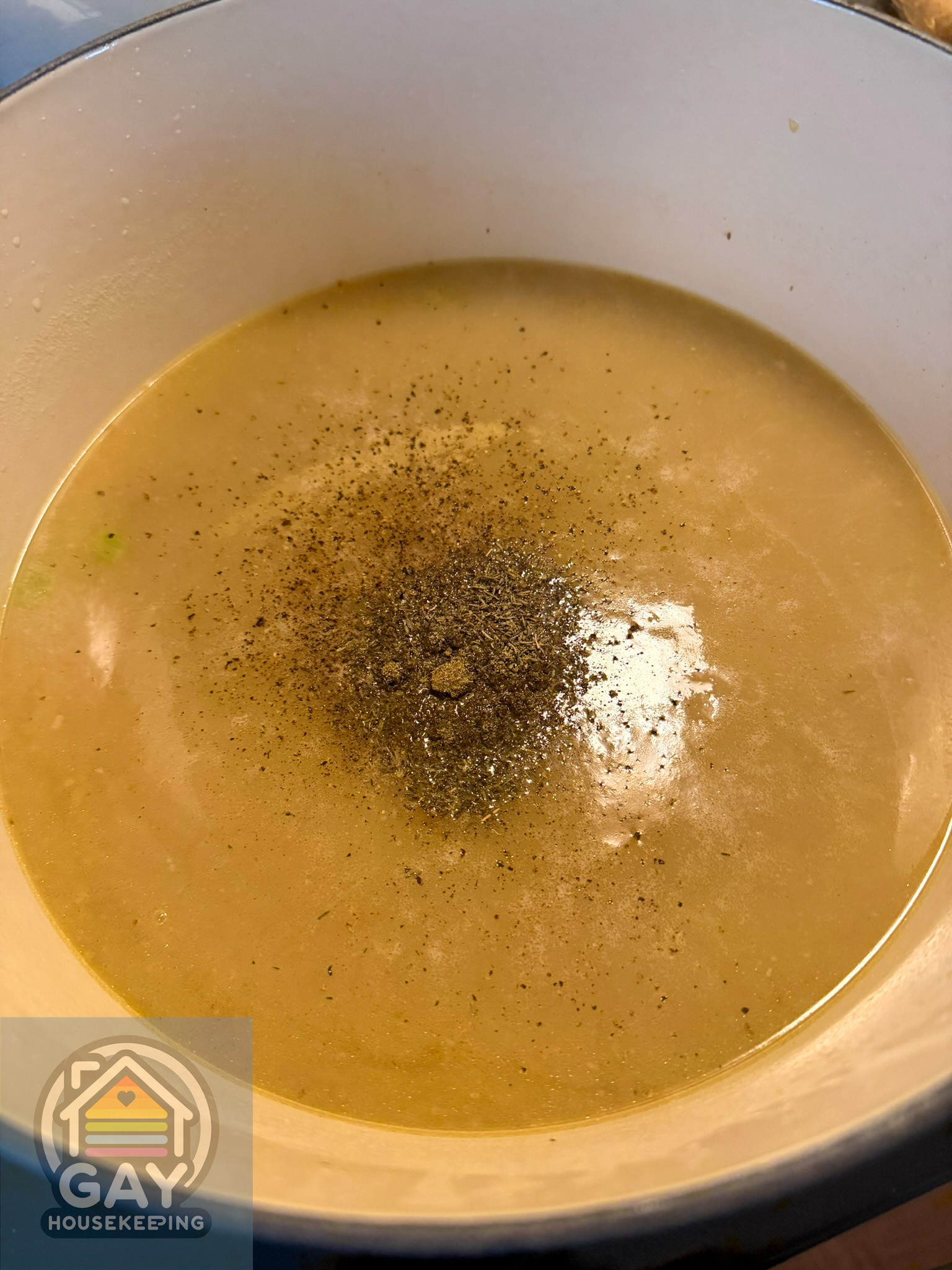 The homemade broth back in the pot with thyme and black pepper, thickening into a silky gravy.