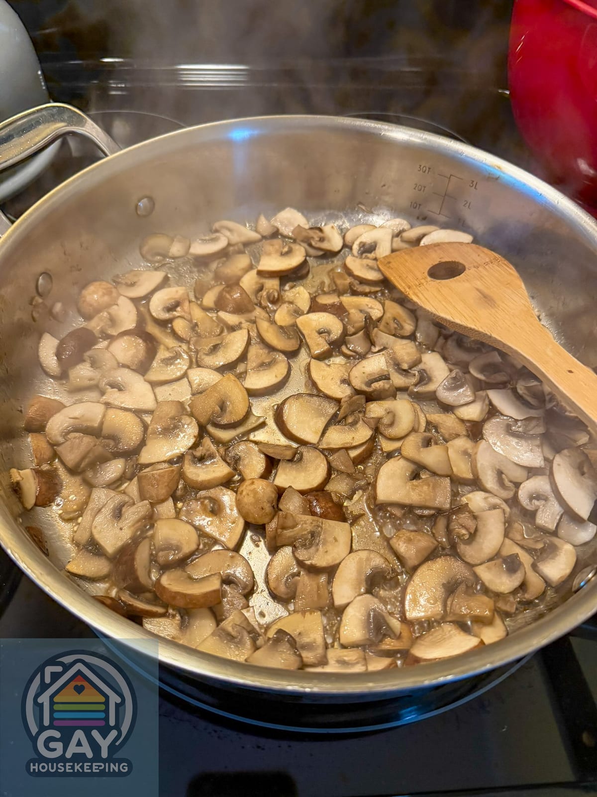 Cremini mushrooms cooking in a stainless steel skillet