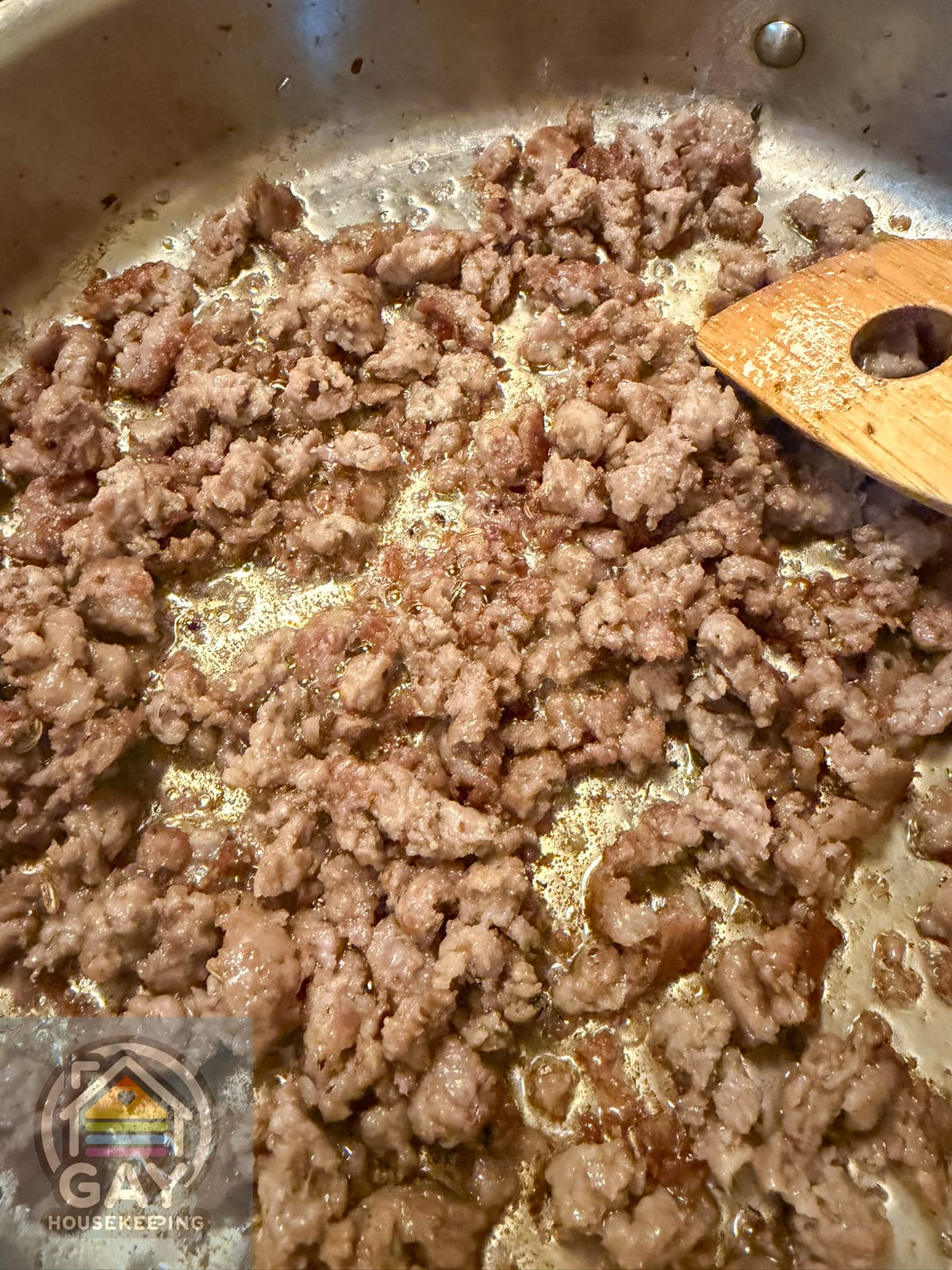 Browned sweet Italian sausage in a stainless steel skillet