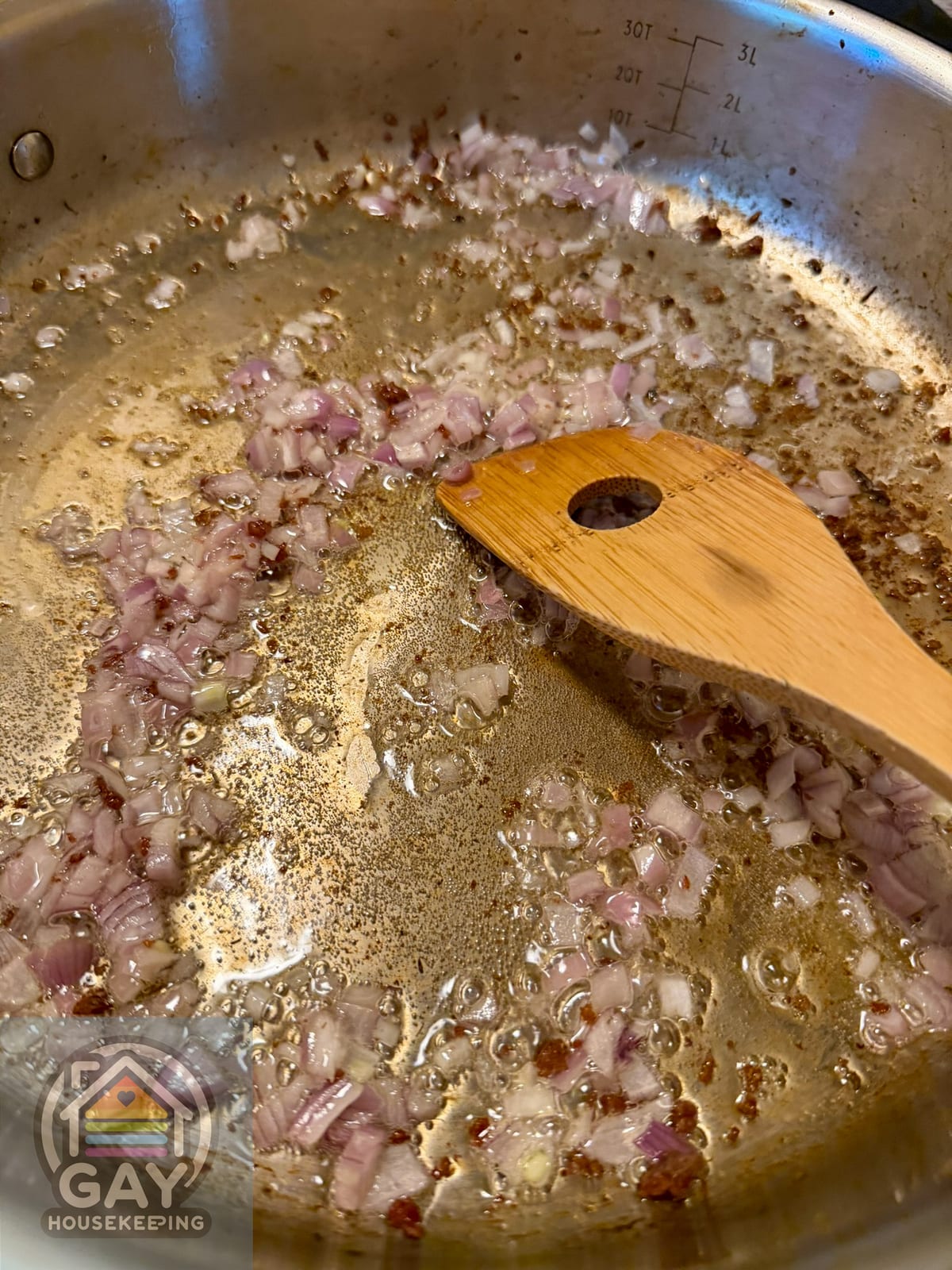 Chopped shallots cooking in the browned fond left from Italian sausage